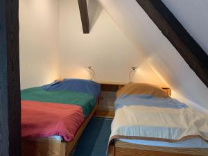 two beds in a room with colored sheets at Historisches Haus Uhlenhorst in Trebel