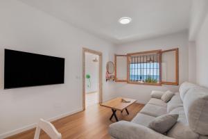 a living room with a couch and a flat screen tv at Primera Linea en Matalascañas in Matalascañas