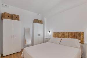 a white bedroom with a white bed and white cabinets at Primera Linea en Matalascañas in Matalascañas