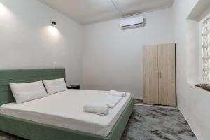 ein weißes Schlafzimmer mit Bett und Schrank in der Unterkunft Azure Nest in Néa Péramos