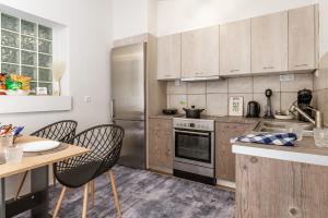 eine Küche mit Edelstahlgeräten und Holzschränken in der Unterkunft Azure Nest in Néa Péramos