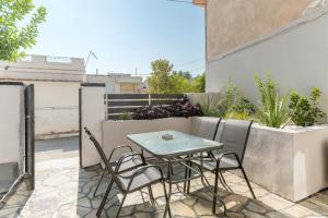 eine Terrasse mit Tisch und Stühlen auf einem Balkon in der Unterkunft Azure Nest in Néa Péramos