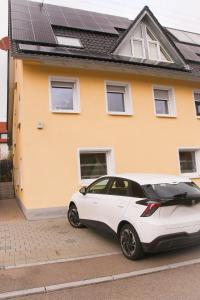 a white car parked in front of a house at Ferienwohnung Talblick in Meßstetten