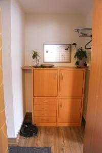 a room with a wooden cabinet and a shelf at Ferienwohnung Talblick in Meßstetten +9 photos