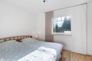 a white bedroom with a bed and a window at Ferienwohnung Gaberle in Balve