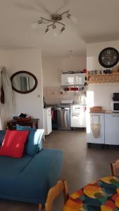 a living room with a blue couch and a kitchen at Appartement Roc Sol I Neou in Puyvalador +13 photos