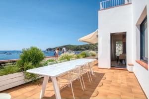 a white table and chairs on a patio at Casa dins el Mar en Calella in Calella de Palafrugell