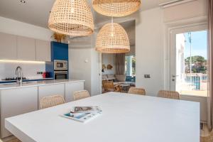 a kitchen and dining room with a white table and chairs at Casa dins el Mar en Calella in Calella de Palafrugell