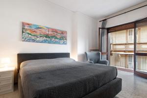 ein Schlafzimmer mit einem Bett, einem Stuhl und einem Gemälde in der Unterkunft Sweet 16 in Rapallo