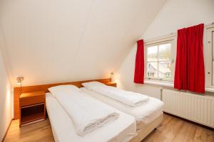 two beds in a room with a red window at Buitengoed het Lageveld 137 in Hoge-Hexel