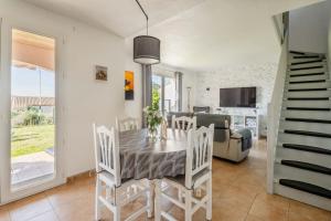 a dining room and living room with a table and chairs at Résidence du lac de Jouarres in Homps
