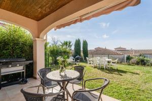 a patio with a table and chairs and a grill at Résidence du lac de Jouarres in Homps