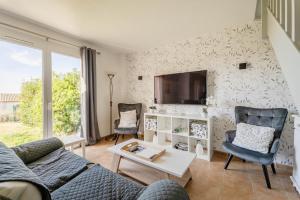 a living room with a couch and a tv on a wall at Résidence du lac de Jouarres in Homps