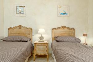 a bedroom with two beds and a table with a lamp at Mazzini Apartment - by And Service in Golfo Aranci +18 photos