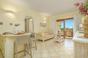 a kitchen and living room with a couch and a table at Mazzini Apartment - by And Service in Golfo Aranci