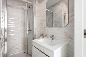 a white bathroom with a sink and a shower at Natalina T2 in Nazaré +17 photos