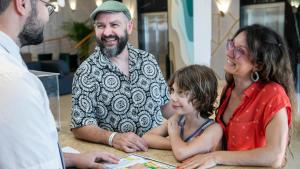 a man and woman sitting at a table with a child at Evenia Olympic Suites in Lloret de Mar