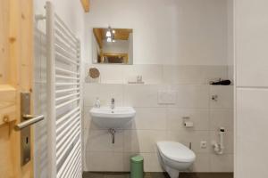 a white bathroom with a toilet and a sink at Ländliche Ferienwohnungen in Öhningen +39 photos