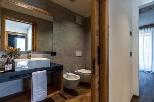 a bathroom with a sink and a toilet and a mirror at Arnica Alpin Lodge in Cavedago +22 photos