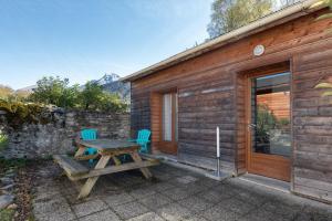 a wooden cabin with a picnic table and two chairs at Chalets De L’arriutort 2 - Laruns in Laruns