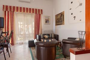 a living room with leather furniture and a window at Bandb Cindy in Navacchio