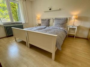 a bedroom with a large bed with two windows at Alpenblick-Hotzenwald in Rickenbach