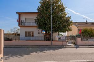 a building with a tree on the side of a street at Bandb Cindy in Navacchio
