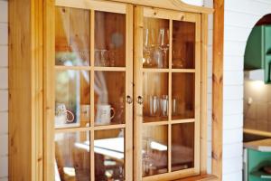 a wooden cabinet with glass doors in a kitchen at Haus Reiher in Lychen +20 photos