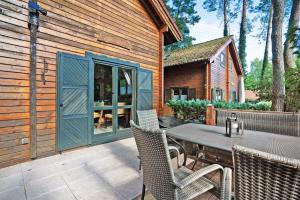 a wooden house with a table and chairs on a patio at Haus Reiher in Lychen