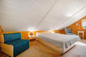 a bedroom with a bed and a couch and a chair at Haus Reiher in Lychen