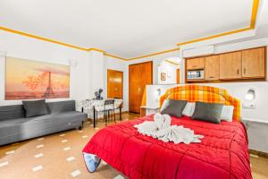 a bedroom with a red bed and a living room at Unique hotel apartment 1-2 in Torrevieja