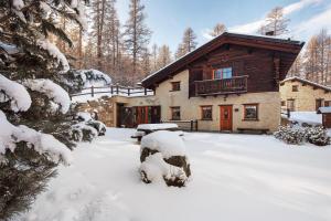 a log cabin with snow on the ground at Chalet Royal in Livigno