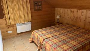 a bedroom with a bed in a wooden cabin at Appartement Airelles B19 in Levassaix