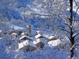 a building covered in snow with trees in the foreground at Appartement Airelles B19 in Levassaix +2 photos