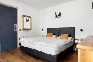 a bedroom with a large white bed with orange pillows at Bnb and Breakfast Pellizzano in Pellizzano