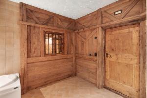 a bathroom with wooden walls and a wooden door at Chalet Royal in Livigno +32 photos