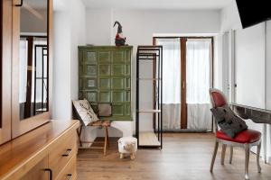 a living room with a green cabinet and a red chair at Bnb and Breakfast Pellizzano in Pellizzano
