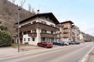 a building with cars parked on the side of a street at Bnb and Breakfast Pellizzano in Pellizzano