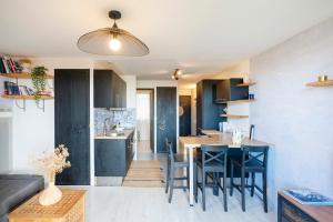 a kitchen and living room with a table and chairs at Appartement Vue Sur La Dune in Seignosse
