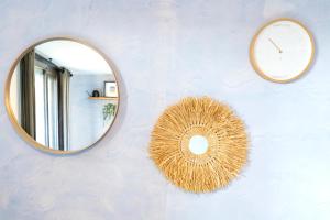 a mirror and a clock on a wall at Appartement Vue Sur La Dune in Seignosse