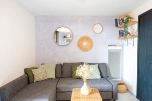 a living room with a gray couch and a table at Appartement Vue Sur La Dune in Seignosse