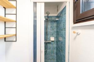 a bathroom with a shower with blue tiles at Appartement Vue Sur La Dune in Seignosse +16 photos