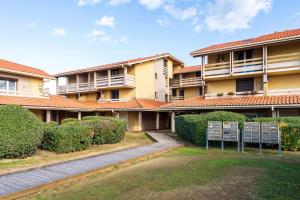 an apartment building with bushes and a pathway at Appartement Vue Sur La Dune in Seignosse