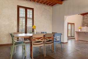 a dining room with a wooden table and chairs at Sunflowers Dimora in Cascina