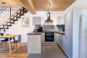 a kitchen with white cabinets and a wooden table at Ländliche Ferienwohnungen in Öhningen