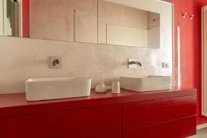 a bathroom with two white sinks on a red counter at Sunflowers Dimora in Cascina +22 photos