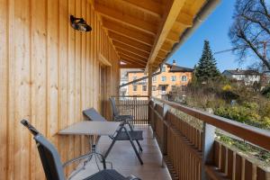 a balcony with chairs and a table on a wooden wall at Ländliche Ferienwohnungen in Öhningen