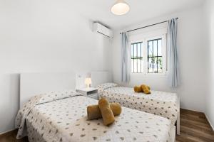 two beds with teddy bears on them in a bedroom at La Casa de la Cala del Moral in Cala del Moral +19 photos