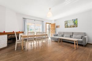 a living room with a couch and a table and chairs at La Casa de la Cala del Moral in Cala del Moral