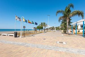 a cobblestone street with flags on the beach at La Casa de la Cala del Moral in Cala del Moral